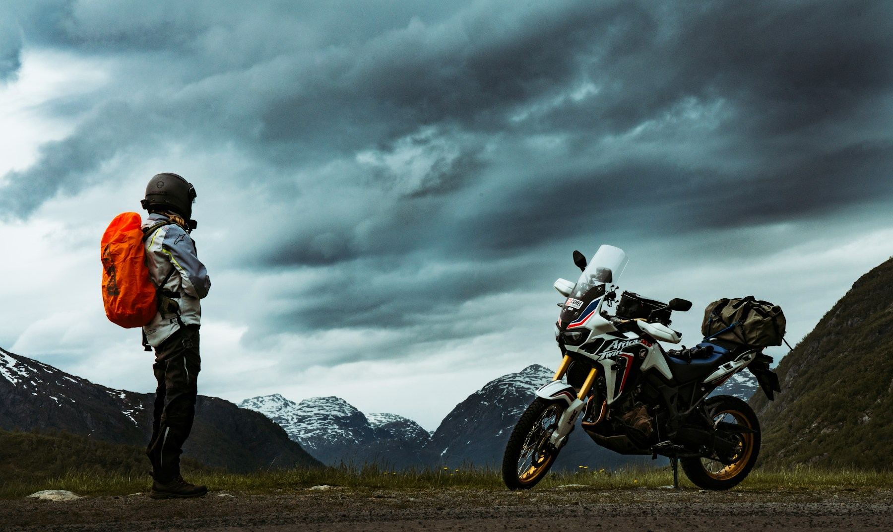 Touring rider beside a fully loaded adventure motorcycle